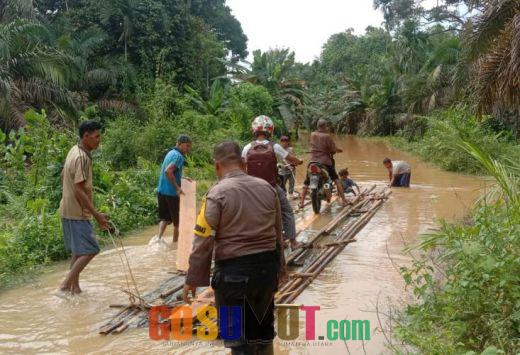 Jalan Terendam Banjir, Bripka Habibi Bantu Warga Siambul Melewati Banjir