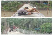 Bhabinkamtibmas Polsek Barumun Tengah dan Guru Perbaiki Lantai Jembatan Gantung yang Rusak 